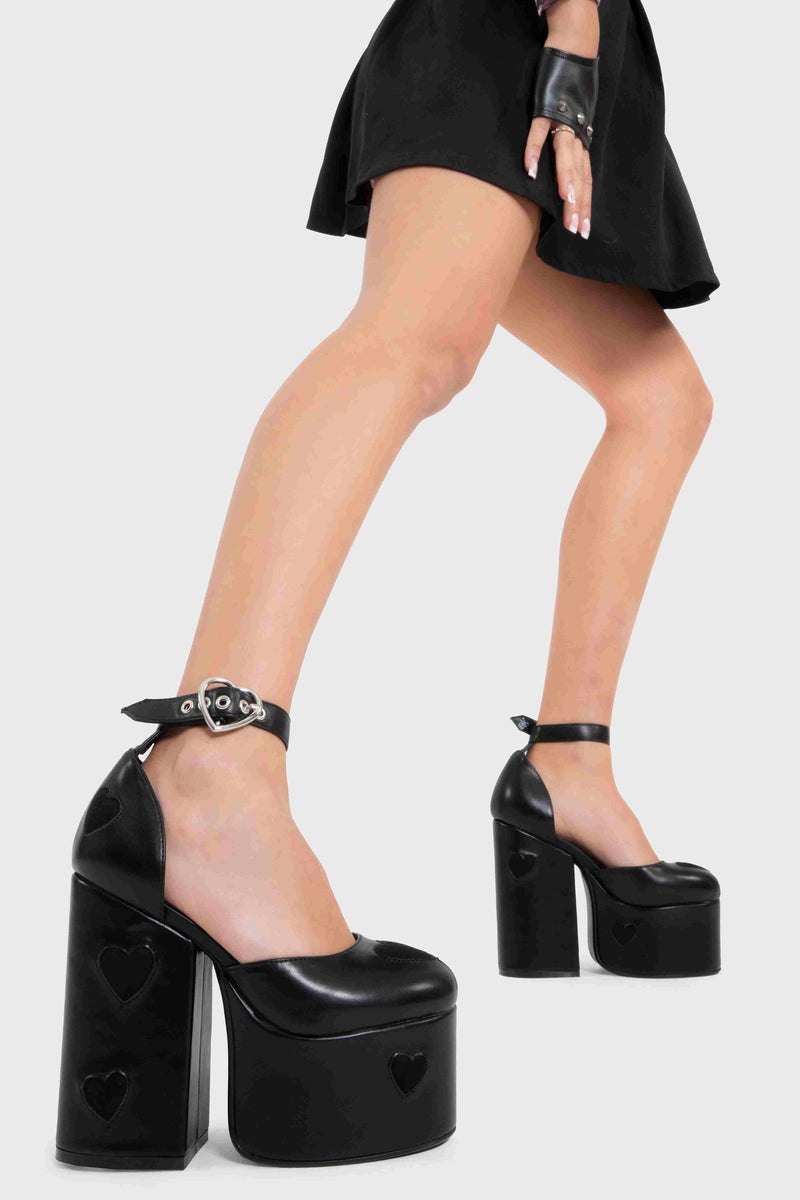 Translate Love Platform Heels in black faux leather. Elevate your style with silver heart details, adjustable strap, and eco-friendly, cruelty-free materials. 100% Vegan