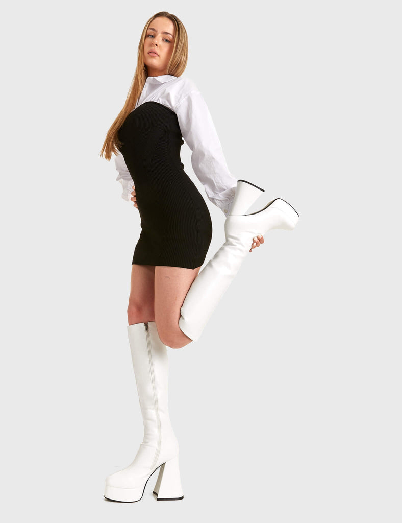 Stylish Uplifts.
  
  Black Swan Platform Knee High Boots in White faux leather. These white vegan Platform Boots feature on our platform sole, elevating your style and making a lasting impression. Made with eco-friendly materials and 100% cruelty-free, these platform boots are as ethical as they are stylish!
  
  
  - Platform Height: 2.6 inch
  - Heel Height: 5.5 inch
  - White zipper 
  - Chunky Platform sole
  - Flared heel
  - Round Toe
  - 100% vegan 
  
  SKU: LMF 1806 - WhitePU