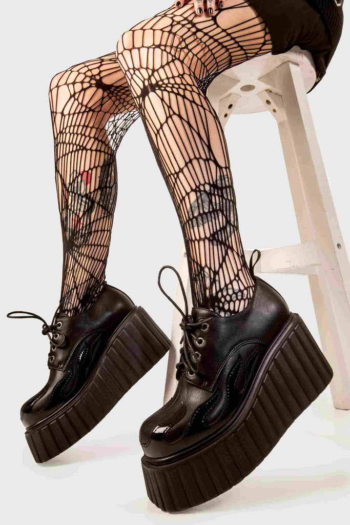 Blaze Runner
  
  Girls On Tour Chunky Platform Creeper Shoes in Black. These black creeper shoes feature a patent black flame across the side of the shoe, stepping on flames and setting hot trends. Made with eco-friendly materials and 100% cruelty-free, these platform boots are as ethical as they are HOT!
  
  - Platform Height
  - Black Laces with black eyelets
  - Patent black flame 
  - Chunky creeper wedge sole
  - Round Toe 
  - 100% vegan 
  
  SKU: LMF 2222 - Black/Flame