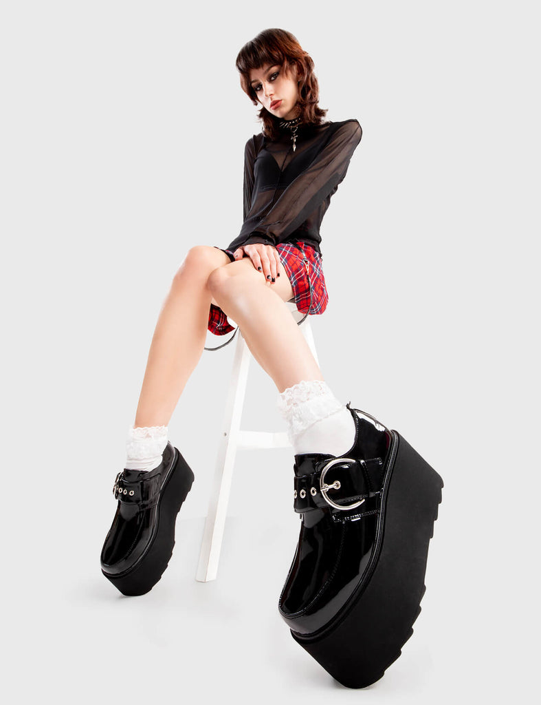 Step Out in Fashion
  
  Grounded Chunky Platform Shoes in Black Patent. These flatform shoes feature a large strap with a large silver 'O' ring buckle. Made with eco-friendly materials and 100% cruelty-free, these platform boots are as ethical as they are Edgy
  
  - Platform Height
  - Large strap
  - Silver buckle and eyelets
  - Flatform Sole
  - Shark's Teeth Grip
  - 100% vegan 
  
  SKU: LMF 3133 - BlackPAT