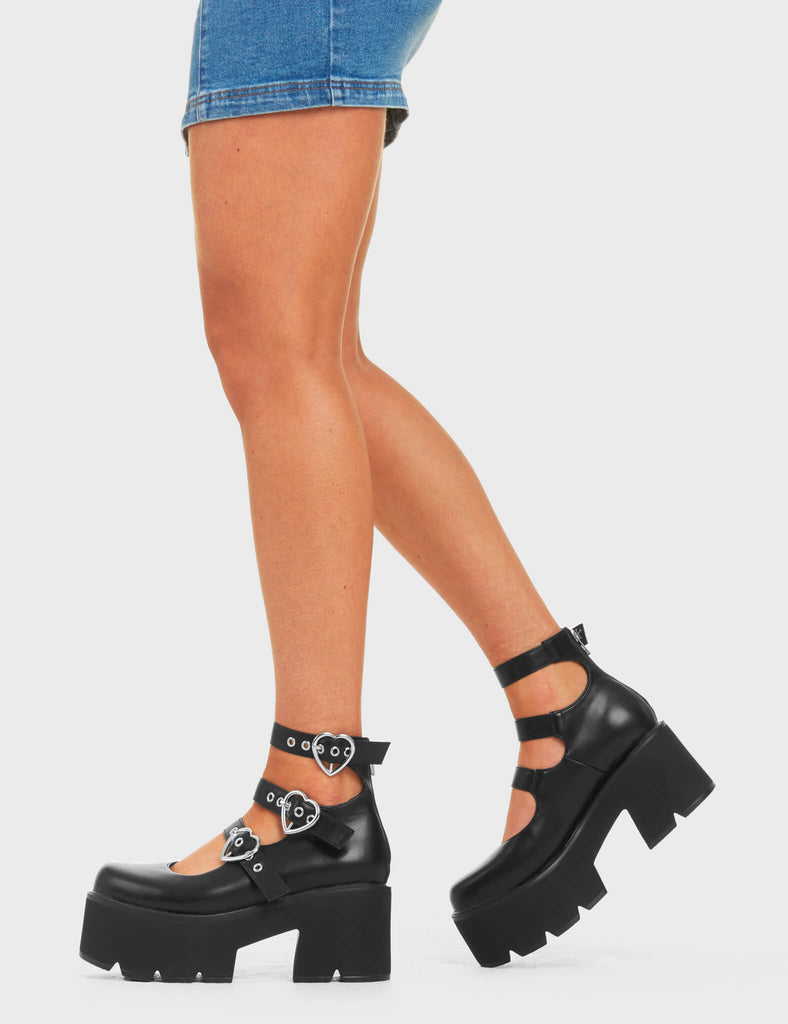 STAY PULLING
 
 Heart Strings Mary Jane Shoes, in Black Faux Leather. These vegan shoes feature three adjustable straps with Heart shaped silver buckles and eylets. All on a chunky platform sole with rubber grip, very classy. Made with eco-friendly materials and 100% cruelty-free, these boots are as ethical as they are edgy!
 
  
 - Chunky Platform
 - Ankle length
 -Three adjustable straps
 - Rubber teeth grip
 - Heart shaped silver buckle
 - Rounded toe 
 - 100% vegan 
 
 SKU: LMF 3905 - BlackPU
