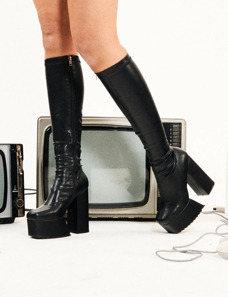 Not Your Basic Boots
  
  Return The Favour Platform Knee High Boots in Black faux leather. These platform boots feature a minimalist design, with a stretchy fitted feel, the perfect pair with any outfit. Made with eco-friendly materials and 100% cruelty-free, these platform boots are as ethical as they are Cool!
  
  - Platform Height
  - Heel Height
  - Black Zipper
  - Fitted feel
  - Knee length
  - Platform sole
  - Shark's teeth grip
  - High Heel
  - 100% vegan 
  
  SKU: LMF 2875 - BlackPU